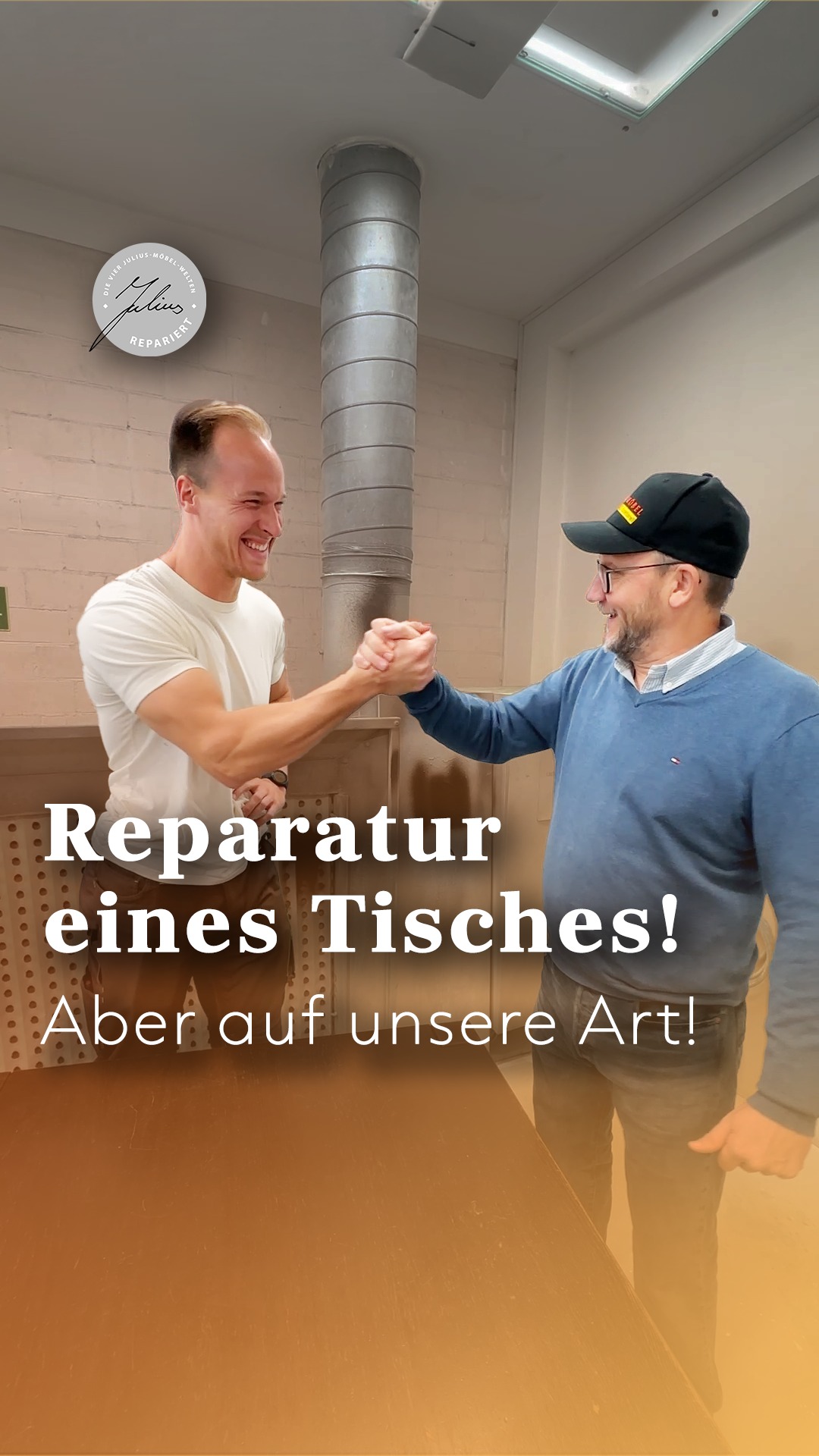 Zwei Männer, die in einer Werkstatt lächeln und sich die Hände schütteln; der eine trägt ein weißes Hemd, der andere eine blaue Jacke und eine Mütze. Der deutsche Text lautet: „Reparatur eines Tisches! Aber auf unsere Art!“.