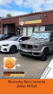 Vor einem Möbelgeschäft namens Julius Möbel standen ein grauer Mercedes-Benz der G-Klasse und ein weißer Audi.