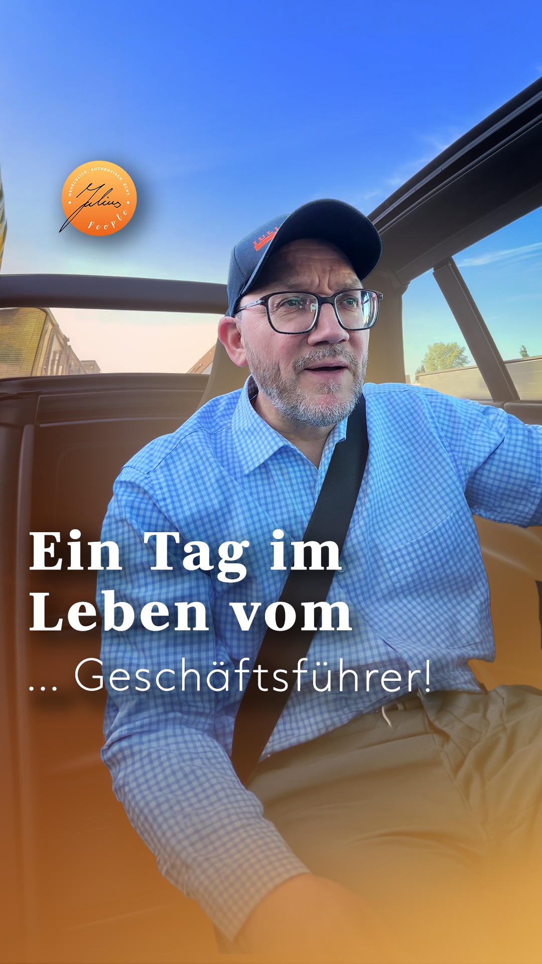 Ein Mann mit Brille und Baseballkappe sitzt in einem Auto; darüber ist ein deutscher Text eingeblendet, der lautet: Ein Tag im Leben des … Geschäftsführers!.